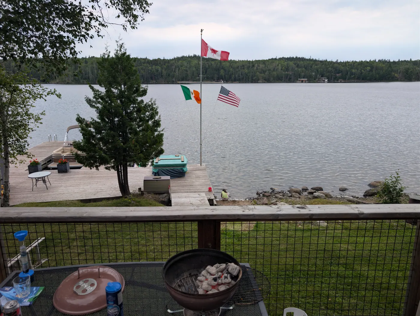 Evening on the deck, flags above the shoreline.