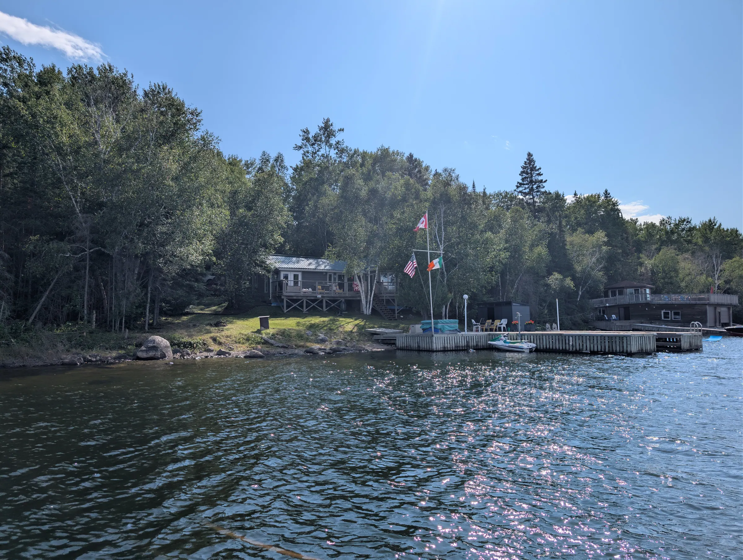 Wide view of the property and its dock from out on the bay, showing the land reaching toward the water.