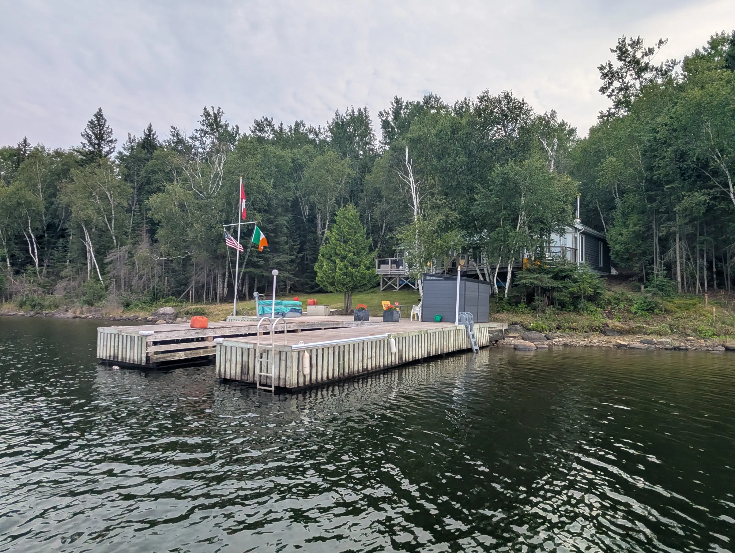 The property from the water on an overcast afternoon, showing the full run of shoreline.