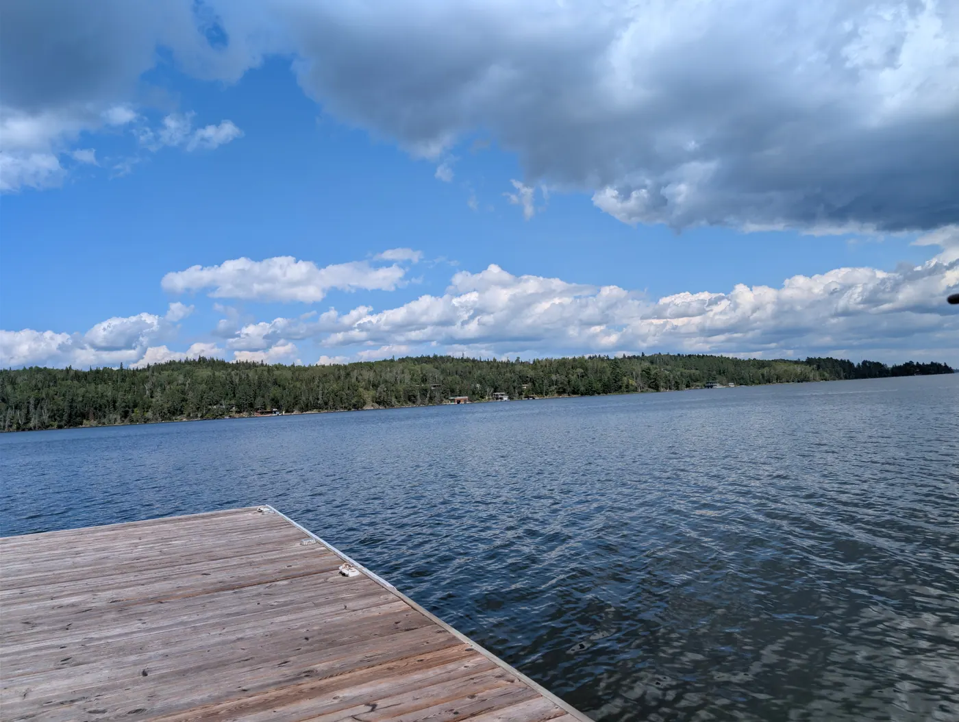 The dock reaching out into open water beneath a blue sky.